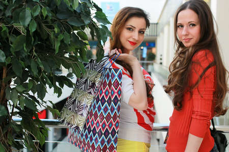 girl with bags walking with his girlfriend at mall and shoppingの写真素材