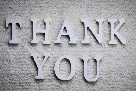 Wooden wthite letter Thank you on the crumpled carpet on the floorの写真素材
