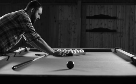monochrome photo young man playing billiards
