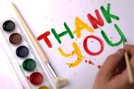 inscription on a white sheet of paper with watercolors "Thank you"の写真素材