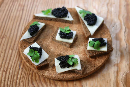 snack black caviar on a wooden brown backgroundの写真素材