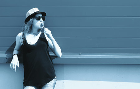 Cute girl hipster in light hat and sunglasses on a summer day