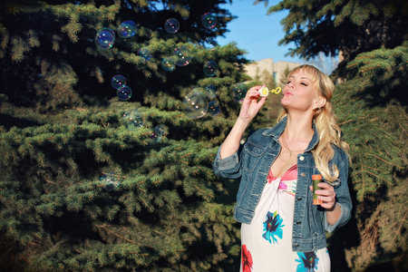 pregnant girl walking around the city park in early springの写真素材