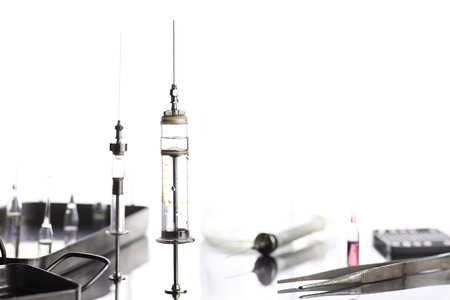 Old retro metal medical syringe and accessories on the table