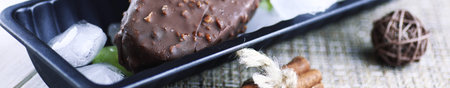 Dessert chocolate ice cream with nuts on a wooden stick