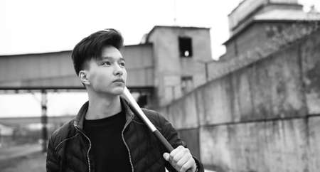 Black White photo of Asian young man outdoors posing at cameraの写真素材