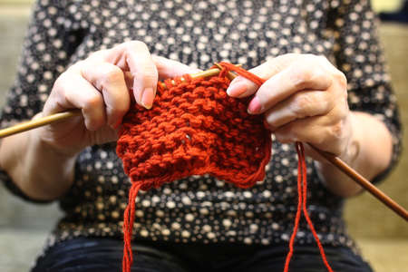 elderly woman is engaged in knitting warm sweaters for her grandchildrensの写真素材