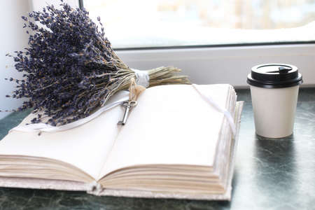 Vintage notebook on green marble windowsill opened with blank pages and a bunch of lavenderの写真素材