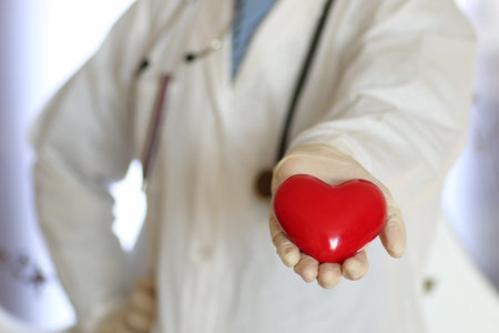 hands in white gloves man dressed in a white robe doctor holding object