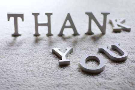 Wooden wthite letter Thank you on the crumpled carpet on the floorの写真素材