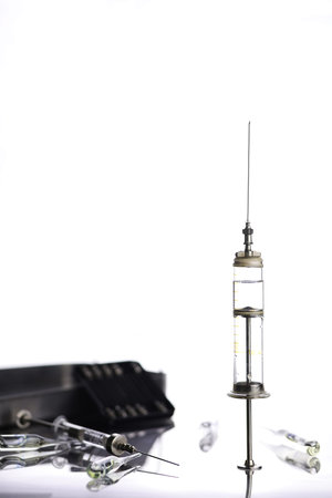 Old retro metal medical syringe and accessories on the tableの写真素材