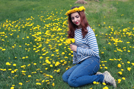 girl resting on a sunny day in a meadow of yellow dandelions