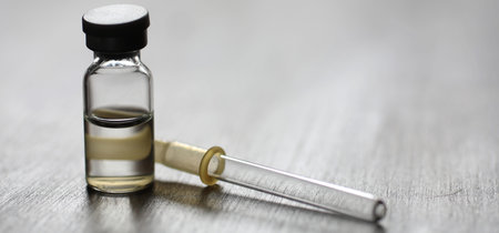 Medicine pipette drop in the nose on wooden background