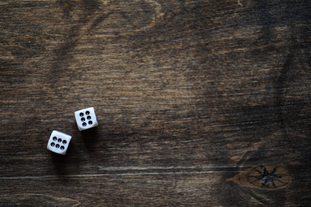 White small dices on a brown wooden texture tableの写真素材