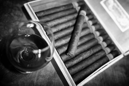 Retro styled photo of large box of Cuban cigars on a wooden table in a presentable package