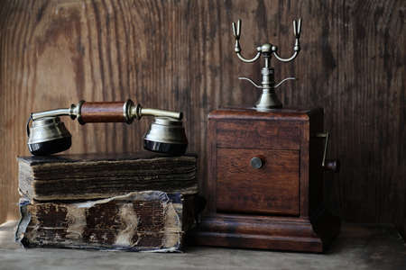 Old telephone and retro book on a wooden tableの写真素材