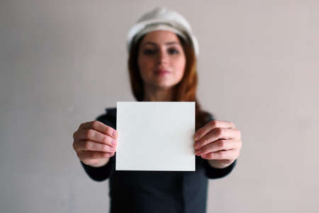 woman with a blank sheet of paper in his hand on construction siの写真素材