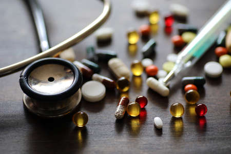 Medications and tablets on a wooden texture tableの写真素材