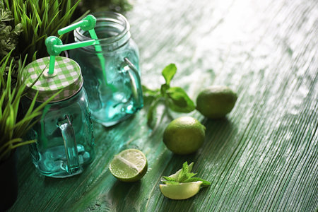 Lemonade from lime and mint in a glass jar on a tableの写真素材