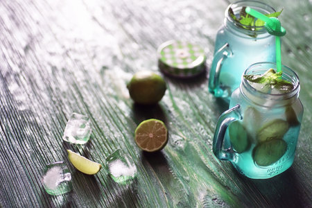 Lemonade from lime and mint in a glass jar on a tableの写真素材