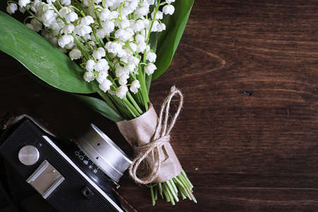 Bouquet of young lilies of the valley on a wooden tableの写真素材