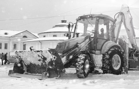tractor for snow removal is parked on a city street after workの写真素材