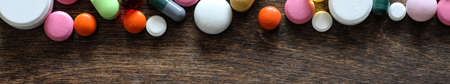 Medical background of various colorful medications on a textured woodenの写真素材