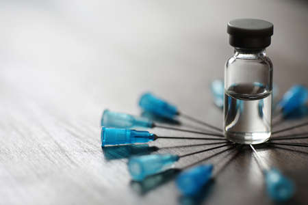 Ampoule and needles from a medical syringe on wooden backgroundの写真素材