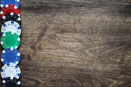 Playing chips on a wooden texture table and a deck of cardsの写真素材