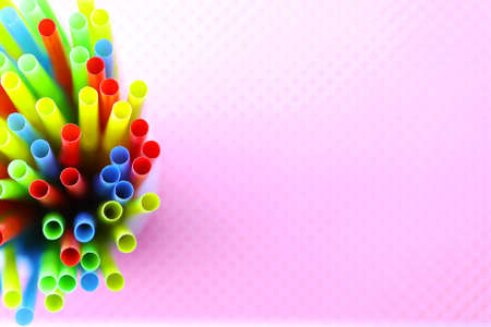 colored plastic cocktail tubes standing in a glass top viewの写真素材