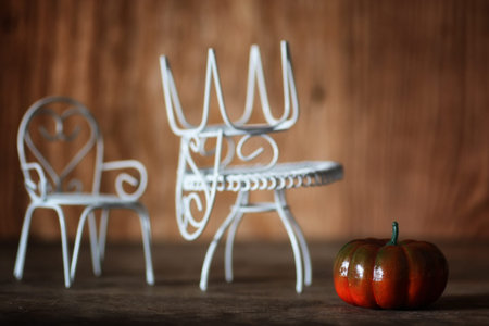 fresh pumpkin in interior wooden room on forged chairの写真素材