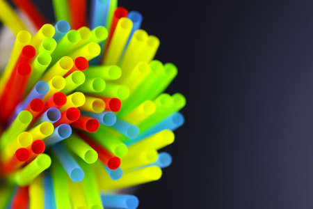 colored plastic cocktail tubes standing in a glassの写真素材