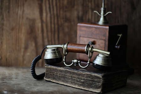 Old telephone and retro book on a wooden tableの写真素材