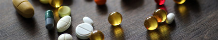 Different colored medications and tablets on a wooden texture table