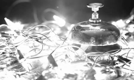 Reception bell on the table and color shining garland on backgroundの写真素材