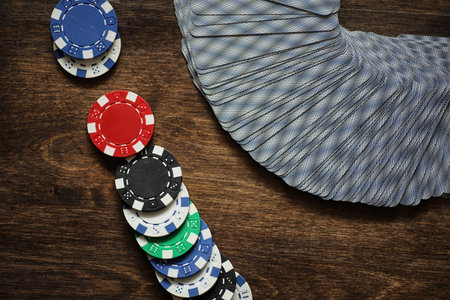Playing chips on a wooden texture table and a deck of cards