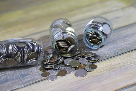 Accumulated coins stacked in glass jars on the floor