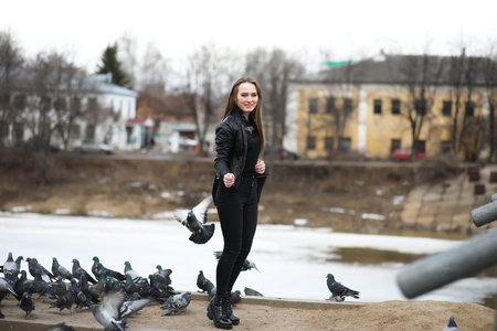 Girl on a walk in the park and a flock of pigeons
