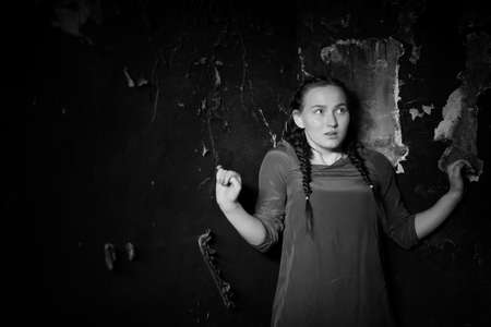 young girl portrait in an old house with burnt wallsの写真素材