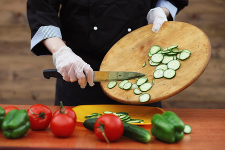The cook cuts fresh farm vegetablesの写真素材