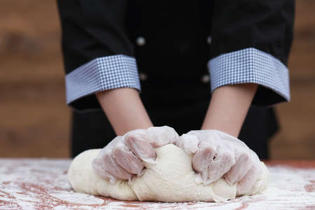 the cook makes flour for baking on the tableの写真素材