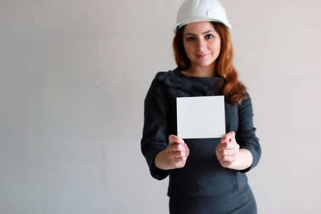 woman with a blank sheet of paper in his hand on construction siの写真素材