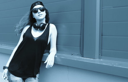 Cute girl hipster in a light hat and sunglasses on a summer day
