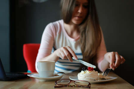 girl in a cafe for a cup of coffee with the notebookの写真素材