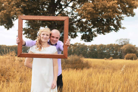 Just married lovers walking in a field in autumn dayの写真素材