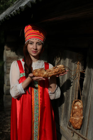 A girl in a traditional dress on a wooden wall backgroundの写真素材