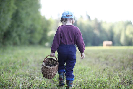 Children gathered in a hike in the nearest forest in search of mushroomsの写真素材