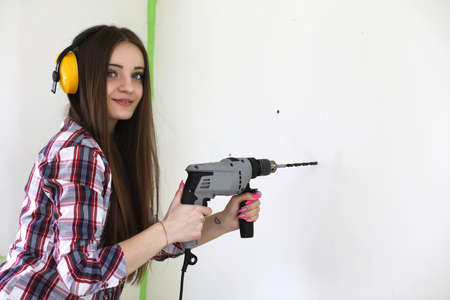A girl doing repairs in the apartmentの写真素材