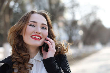 Business lady in a suit outdoors with mobile phoneの写真素材