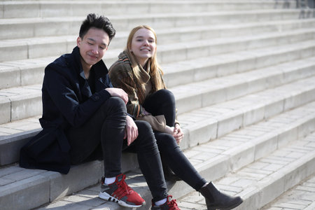 A couple of friends sitting on the stepsの写真素材